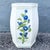 Charming vintage ceramic garden stool featuring a crisp white glazed body decorated with dimensional hand-painted cobalt...