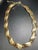 This mid-century Crown Trifari choker necklace features flexible, articulated links composed of swept, flame-like ribbons...