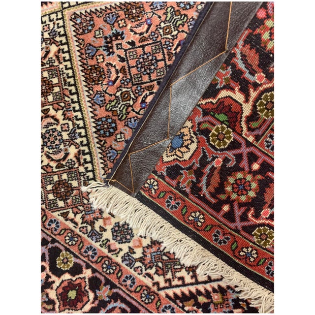 A hand-knotted wool vintage Persian runner with a traditional design that seamlessly complements both modern and...