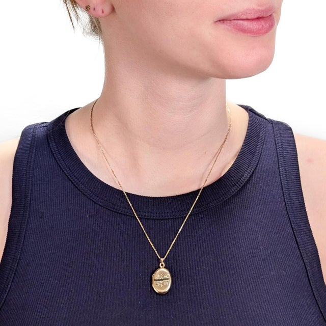 A fine, vintage gold locket. In 14 karat yellow gold. With bright-cut floral decoration to the front and a smooth back....