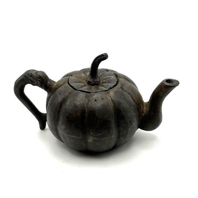 The object is a water dropper made of iron. It was an object found on a scholar's table, and its function is defined by...