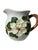 This ceramic pitcher features a raised magnolia flower design with green leaves against a white background with a wooden-...