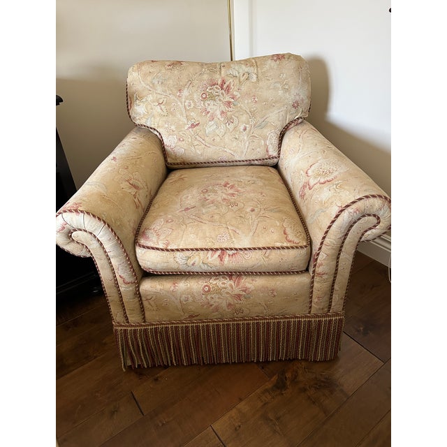 Stunning Ralph Lauren floral fabric covered chair and ottoman. Trimmed in coordinating braiding and heavy fringe.