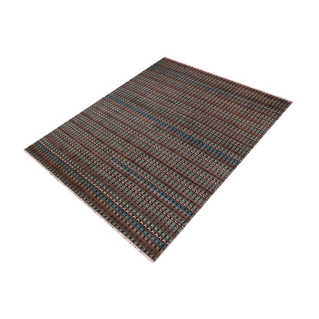 Elevate your interior with this hand-knotted high-low wool area rug, designed to bring depth and dimension to any room....