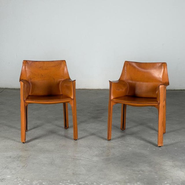 A beautiful pair of cab 413 armchairs designed by mario bellini for cassina, presented in their original cognac saddle...