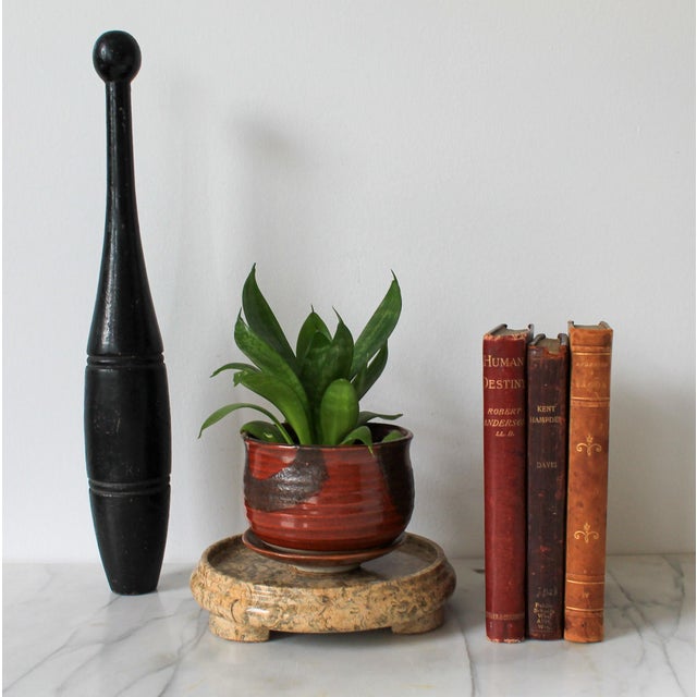 Vintage footed stone plant stand or candle holder. It is made of stone and has a round top with scrolled corners. It can...