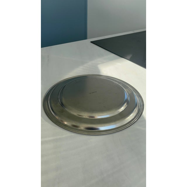 Elegant round stainless steel tray by Guy Degrenne, an emblem of functional and timeless French design. with its clean...