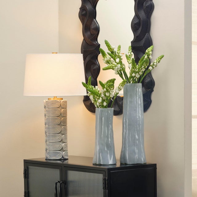 Repeating geometric patterns in ceramic are accented with hand applied drip glazes in a soft blue to create the richly...