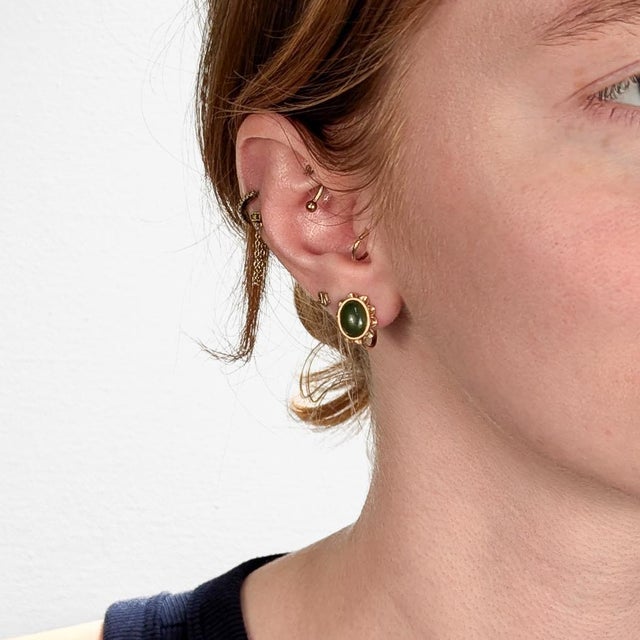 A fine pair of vintage gold & jade screwback earrings. In 14 karat yellow gold. Each with a central jade (nephrite)...