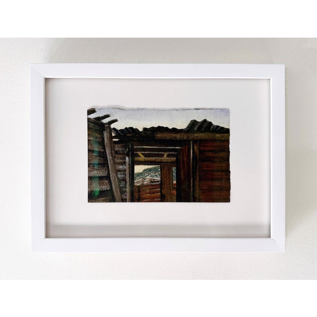 This artwork depicts an interior view of a rustic structure, framed by weathered wooden beams that lead the eye toward a...