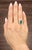 A captivating 3.42-carat natural emerald-cut emerald commands attention with its rich green hue. Encircled by...