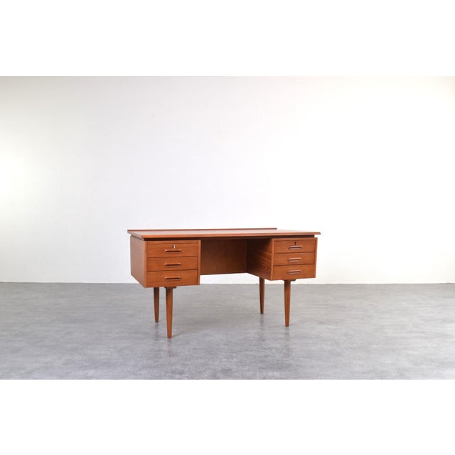 A Danish desk from the 1960s, crafted in teak wood and representing the classic mid-century modern style. While its form...