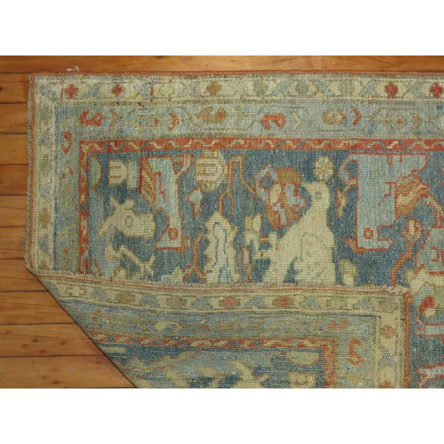 A decorative pictorial Persian Malayer Runner with a flurry of white and blue birds and pigeons on a soft blue background,...