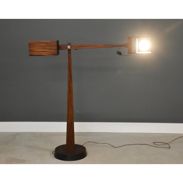A mid century modern mahogany large floor lamp made by Montague. Tilt head. Circa 1960’s. Made in USA. Fulcrum to the end...