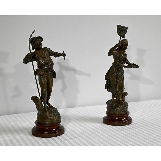 Subjects in regula with brown patina, titled "Fisherman" and "Fisherwoman", by the French sculptor Georges Maxim...