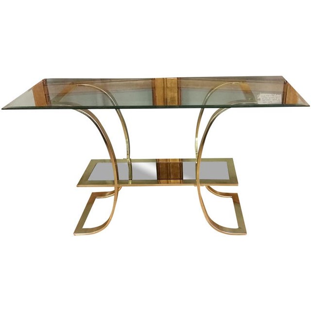 Here's a stunning design for the Hollywood Regency lover. This brass and glass console table features curved legs...