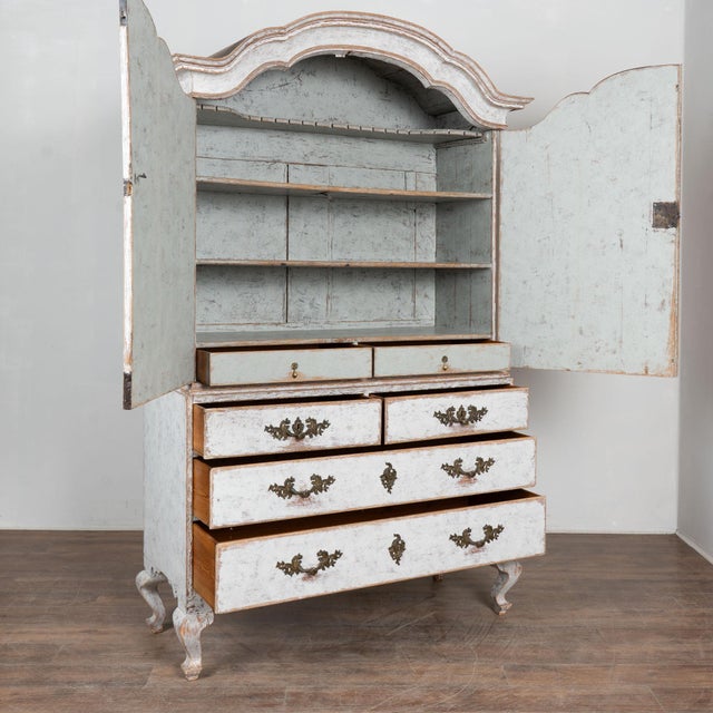 Late 18th century Swedish wedding cabinet crafted in pine. The cabinet features a white painted finish that was applied...