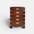 Chest of drawers executed in dark-stained wood with recessed brass handles and external brass corner fittings. inspired by...