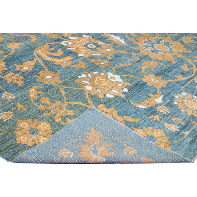 Beautiful modern Oushak hand-knotted wool rug with a blue field. This Oushak rug has orange and ivory accents in a...
