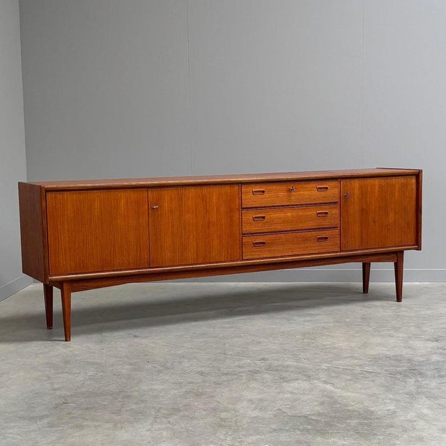 Remarks: Mid century sideboard by Bartels, Germany 1960s. Teak veneer with three doors and three drawers. Sideboard is in...