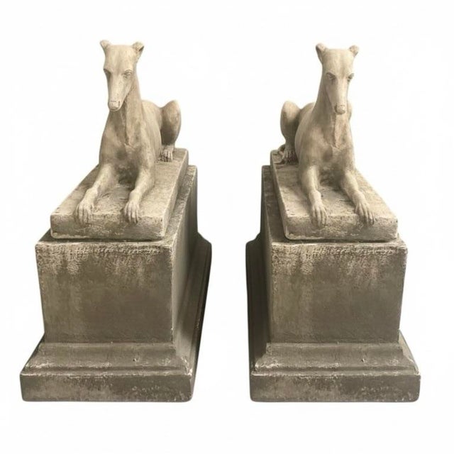 A pair of monumental recumbent greyhound (or whippet) statues. Masterfully cast with a focus on lithe, athletic...