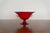 A striking vintage ruby red Murano art glass footed compote featuring a wide flared bowl, short pedestal base, and applied...