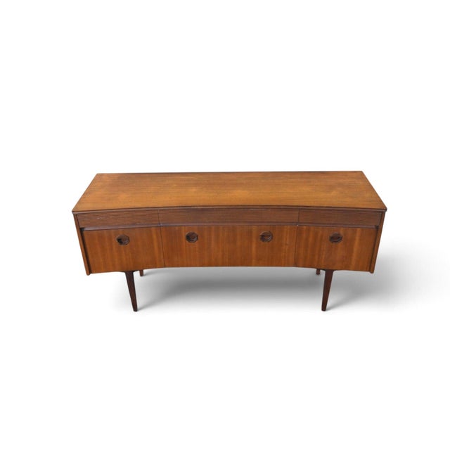 This bow front dresser was designed and produced by Elliotts of Newbury in England during the 1960s. The case combines...