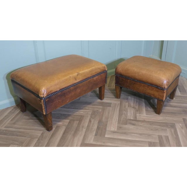 A set of two sturdy leather library foot stools this very attractive vintage duo are upholstered in very soft tan studded...