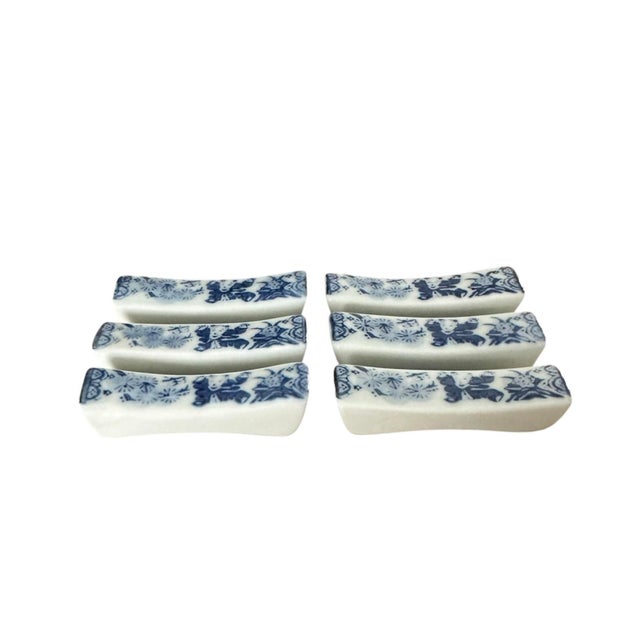 A beautiful set of vintage chopstick rests. Features blue Japanese patterns on a white ceramic, pillow form body. Unmarked.