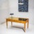 Large desk raised on tapered legs with brass ball feet and three drawers with round pulls. The writing surface is outlined...