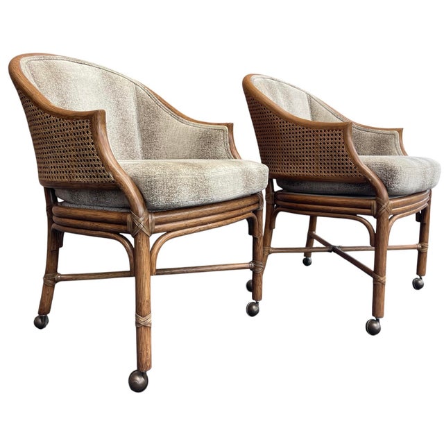 A beautifully designed pair of McGuire San Francisco Toboggan dining armchairs featuring sculptural rattan frames, woven...