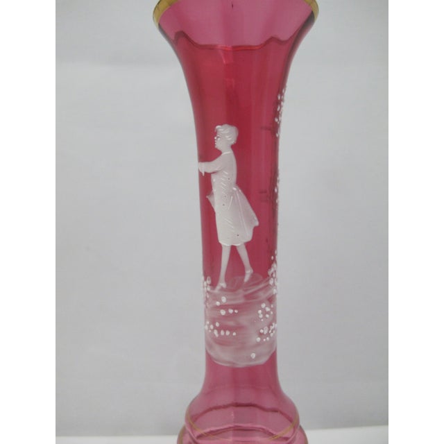Czech red glass with enamel hand painted figural scene showing a boy or young man holding a bird. Measures 7 1/4" tall x 3...