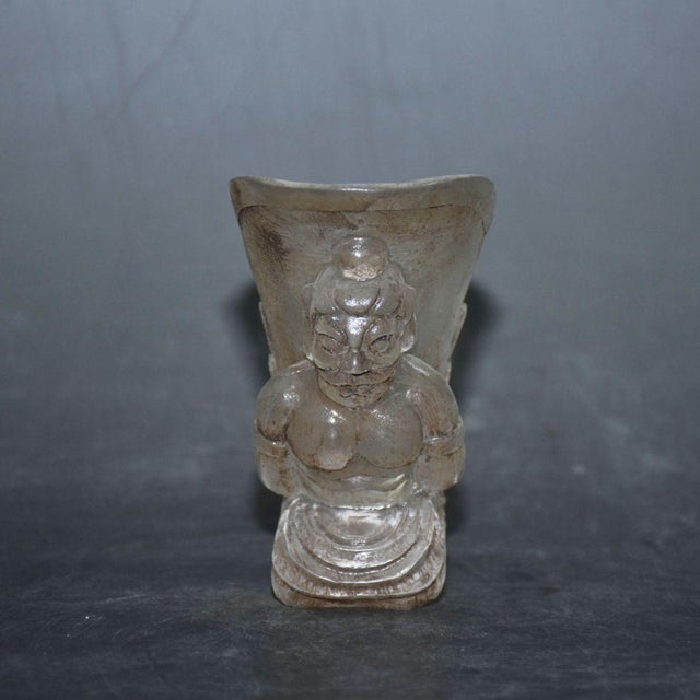 Unique hand-carved liuli glass wine cup sculpted with a kneeling female figure supporting the flared cup body. Fine relief...