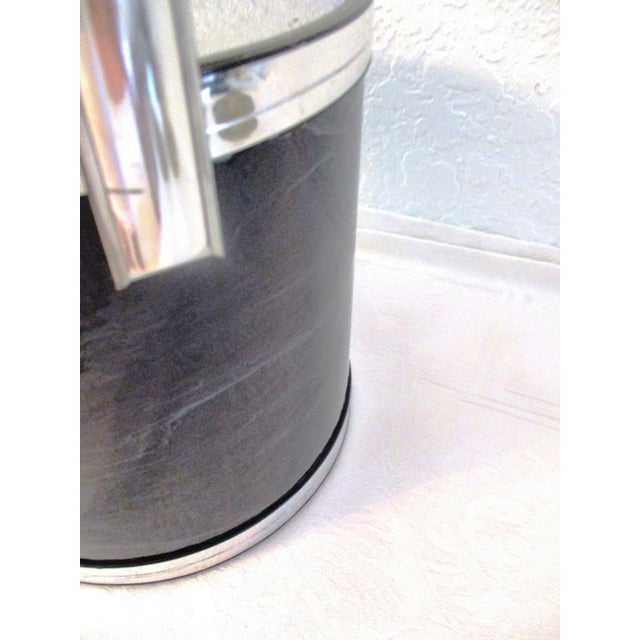 Glamorous lidded ice bucket featuring a black faux marble with gray veining exterior and silver-shaded vinyl trim at base,...