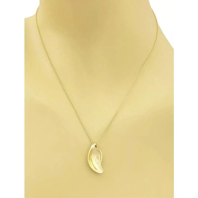 This beautiful authentic vintage pendant and chain is from Tiffany & Co. It is crafted from 18k yellow gold with a...