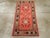 An antique East Turkestan Khotan throw rug. The salmon-pink field of this lively small scatter from the Xinjiang oasis...