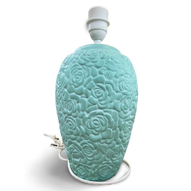 Baluster-shaped lamp base in molded ceramic, entirely covered with a high-relief decoration of stylized roses, repeated...