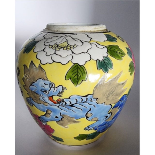 A very nice vintage famille jaune vase using enamels in blue, brown, green, white and rose, depicting dragons and foo...