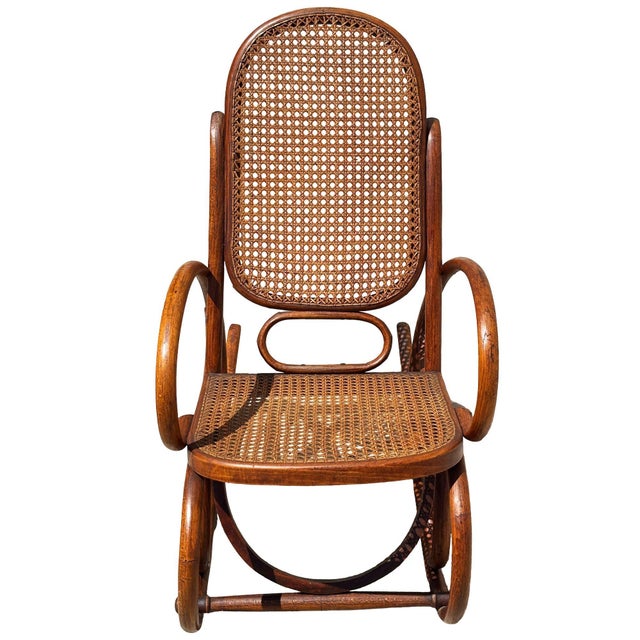Turn of the century Vienna Secession oak child size rocking chair features an elegant, sculptural frame crafted from warm-...