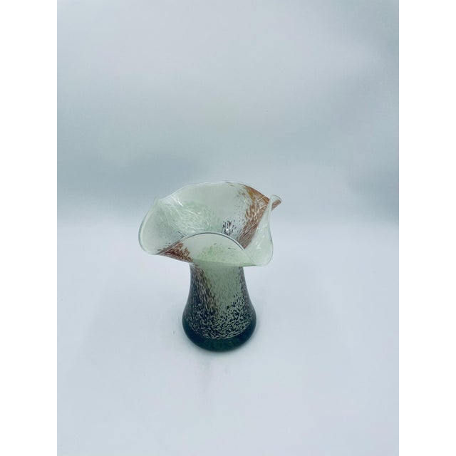 A decorative vintage vase made of high-quality art glass. The vase features a goblet-shaped design with a flared and...