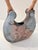 This distinctive raku‑style ceramic vessel features an organic, sculptural form with a smooth, smoke‑patterned surface...