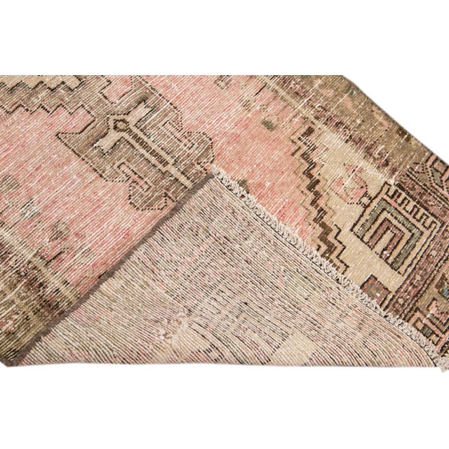 Beautiful Vintage Tribal hand-knotted wool rug with a pink field. This rug has brown and tan accents all-over a geometric...