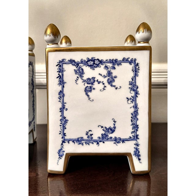 A handsome pair of square, tapered cachepots in the classic blue-and-white chinoiserie style, hand-painted with a delicate...