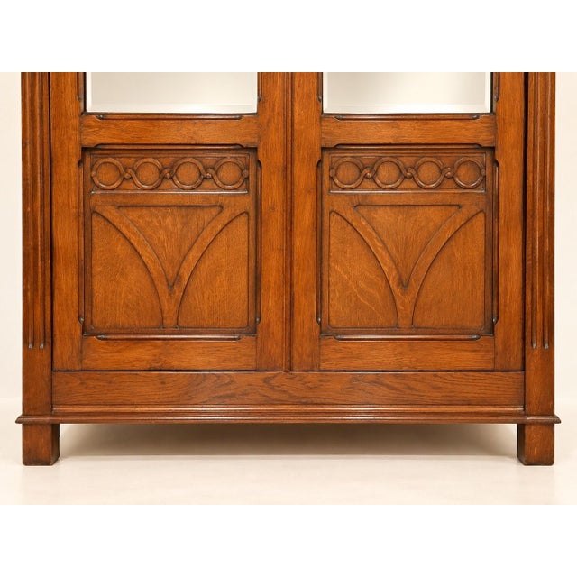 The two doors feature large beveled mirrors in their upper section, framed by fluted pilasters. The lower section is...
