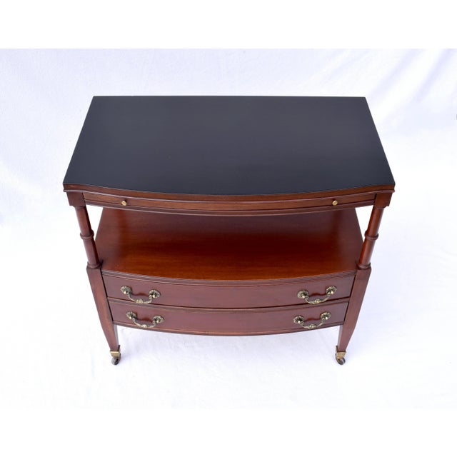 A two tier Mahogany server in the Regency style featuring pull out shelf set on brass castors with two dovetailed drawers...