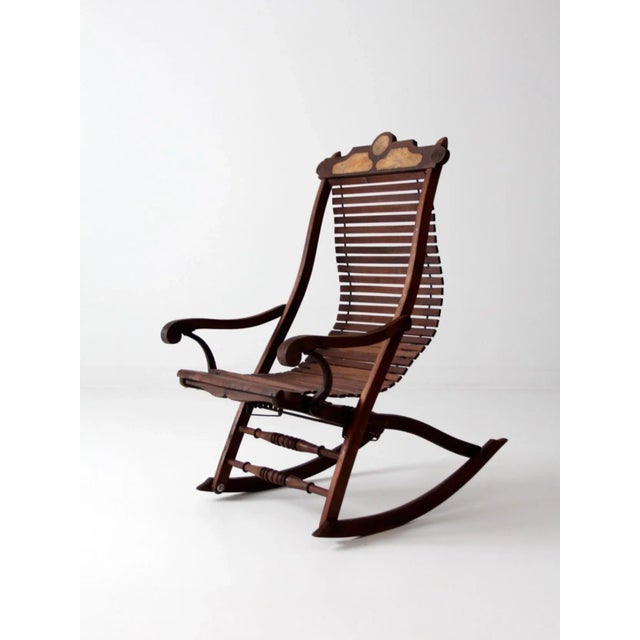 This late 19th century Victorian rocking chair reflects Eastlake influence with its sculpted crest rail, carved arm...