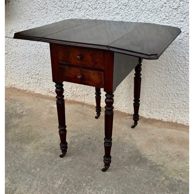 This elegant 19th-century Victorian drop-leaf side table is crafted in richly toned wood, showcasing the warm colour and...