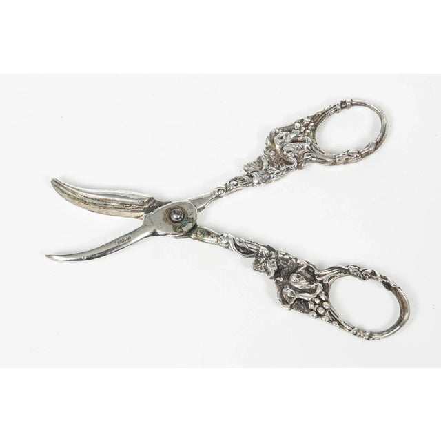 Antique solid sterling silver grape shears featuring a grape and vine floral design. Marked sterling on the blade area....
