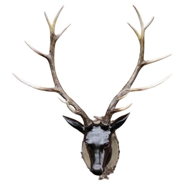 An impressive and highly decorative wall-mounted stag head sculpture, featuring a magnificent set of branching antlers and...