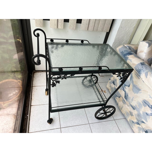 Vintage wrought iron bar /tea cart. It has 2 Tier Glass tops measuring 18” x26”. Black iron, with acorn and leaf motif....